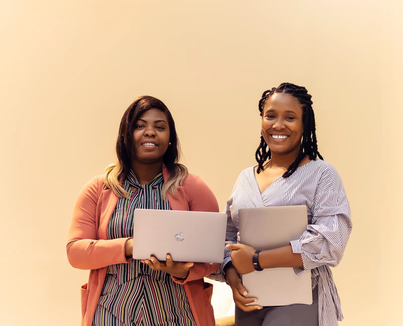 Two business professionals holding laptops